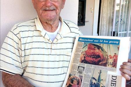 Oom Pilla Groenewald met die koerantberigte van 20 Januarie 1987.   Die vangs van die reusagtige â€˜witdoodhaaiâ€™ soos wat dit destyds genoem is, het  opspraak verwek. 