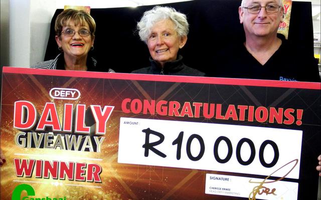 Dis mos hoe â€˜n R10 000 glimlag moet lyk. Claudette Barnes ontvang haar prys van Corrie Kotze, Defy se verteenwoordiger (links). Bayview Meubels se eienaar, Jan Barnard (regs) glimlag heel tevrede.