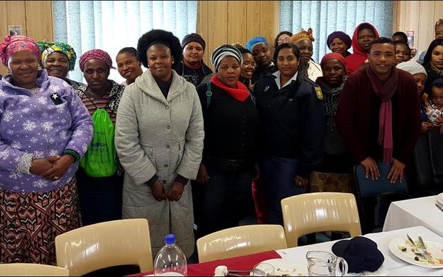 Hierdie groep tevrede vrouens, wat voorheen aan gesinsgeweld onderworpe was, het pas â€˜n middagmaal geniet wat deur Gansbaai SAPD vir hulle gereÃ«l is. Links voor en agter is lt.kol Moshi (Stasiebevelvoerder) en sers Testa. Voor 3de van links is me Thomas, 4de konst Naidoo, 5de mnr Jansen en 6de me Claassen saam met die groep vroue.