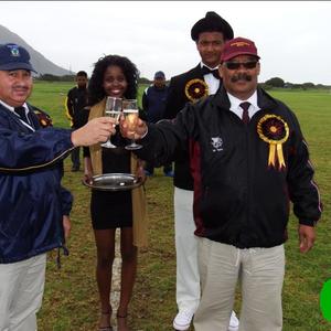 Die twee skoolhoofde, mnr Wilfred Taylor (links) van HoÃ«rskool Eben DÃ¶nges en mnr Tommy Wilson van Gansbaai Academia klink â€˜n glasie sjampanje voor die hoofwedstryd. Agter hulle is die sjampanje-nooi, Anelisa Xhego en haar begeleier, Ralph-Vino Richter.