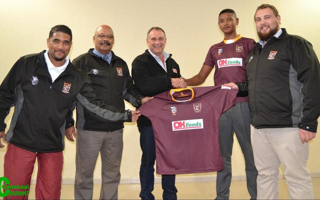 Chris van Rensburg, eienaar van Gansbaai OK Foods, oorhandig Academia se o/16 rugbyspantruie. Van links is Garren Verhoog (afrigter), Tommy Wilson (skoolhoof), Chris van Rensburg (Gansbaai OK Foods), Ralph-Vino Richter (spankaptein) en Gericke van Eck (afrigter). 