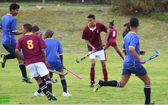 Malin Kaptein (middel) van die Sharkies se hokkiespan lei hier â€˜n aanval op Eben DÃ¶nges se spelers.