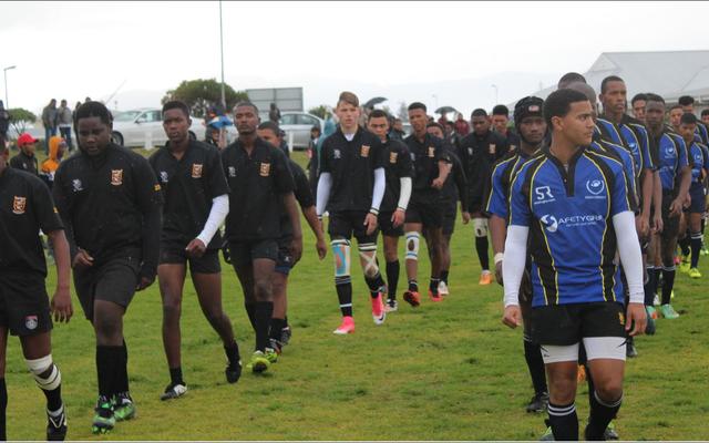 Links stap die gedugte o/19 rugbyspan van die Sharkies saam met Eben DÃ¶nges se o/19â€™s op die veld vir â€˜n titaniese stryd, met die Sharkies wat 43-0 gewen het.