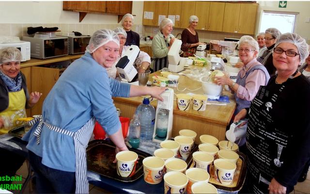 Daar word behoorlik gewoeker met diÃ© dat Herberg-aan-See Tehuis vir Bejaardes (HaS) se jaarlikse basaar om die draai is. 1 000 pasteie is reeds netjies weggebÃªre vir die groot dag en op die meegaande foto is â€˜n groep vroue besig met die tweede baksel van â€˜n duisend pasteie. 100 dosyn koeksisters is ook gereed vir die groot koop- en eetdag wat Saterdag, 23 September plaasvind.  Kleinkoekies, groot koeke, plaasvars groente en smaaklike etes wag op basaargangers. 