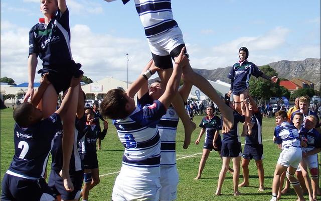 NieldrÃ¨ Groenewald spring hoog vir die bal in die lynstaan, met Charl Eksteen (voor) en Billy Brown (direk agter hom) wat hom ondersteun. 