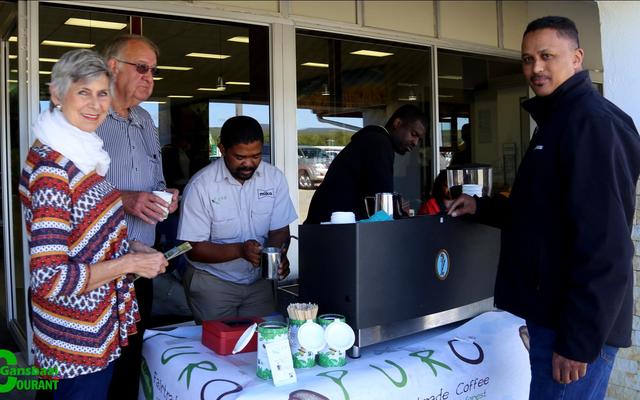 Die eienaars van Sunset Place Farm, Muriel en Chris Burls kry â€˜n bietjie boeretroos van Xolani Soshweshwe van Miko en Puro Coffee.  Musa Noyni is baie besig op die agtergrond en Ashwell Gillion, vloerbestuurder by Overberg Agri, wag sy beurt af.