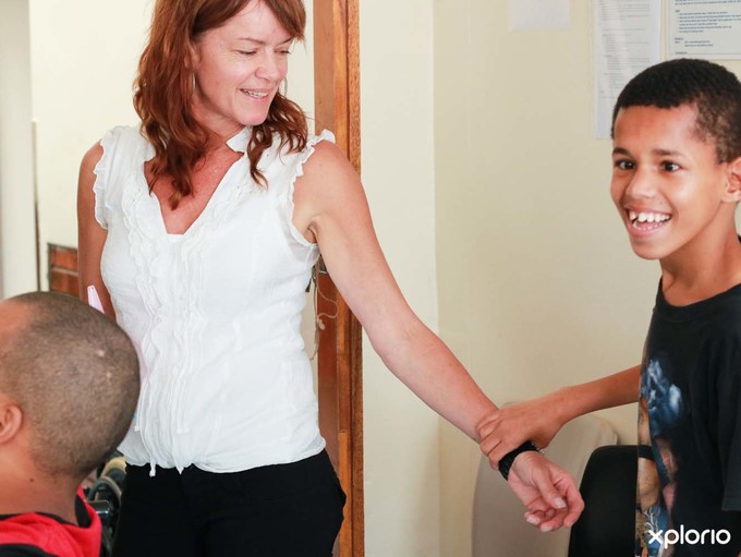 Elim_home_child_reaching_out_to_xplorio_staff_1518417973_1544165747