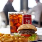 Xplorioâ„¢ Struisbaai - Catch Cook Restaurant - 200g Local grass fed beef burger served on a toasted sesame bun with tomato, lettuce, house sauce and chips. Add toppings: - caramelised onions- cheddar, mozzarella, feta- cheese sauce, garlic sauce, avo