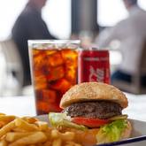 Xplorioâ„¢ Struisbaai - Catch Cook Restaurant - 200g Local grass fed beef burger served on a toasted sesame bun with tomato, lettuce, house sauce and chips. Add toppings: - caramelised onions- cheddar, mozzarella, feta- cheese sauce, garlic sauce, avo